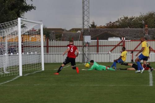 Enfields Ryan Blake (yellow, L) beats keeper Sam Cowler but Matt Cripps (6) clears off the line
