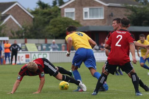 Enfields Sam Youngs (yellow) takes the ball past a desperate challenge from Josh Gould (L)