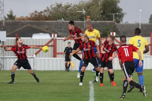 Simon Thomas (yellow) heads Enfields goal