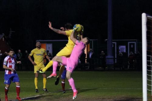 Dorking keeper Slavomir Huk catches under pressure from Matt Johnson