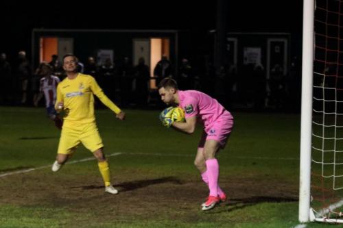 Dorking keeper Slavomir Huk reaches the ball ahead of Liam Hope