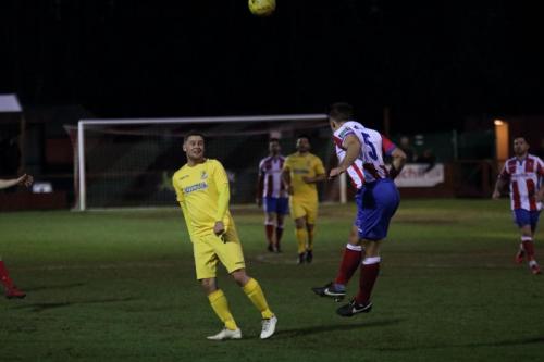 Dorkings David Ray (R) heads clear from Liam Hope