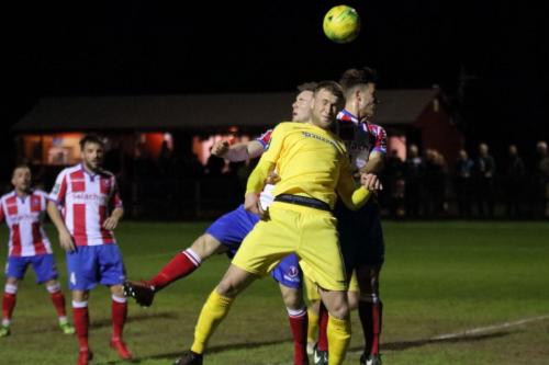 Enfields Brad Wadkins (yellow) challenges for a long throw