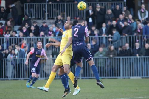 Enfields Simon Thomas (yellow) wins a header against Quade Taylor