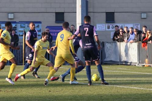 Enfields Tyler Campbell (yellow, centre) tries to find a way through the defence