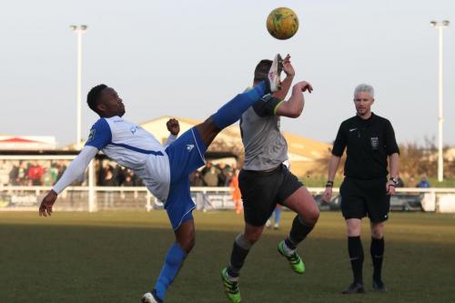 Enfields Ryan Blake is penalised for a high boot against Sammy Moore