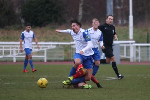 Needhams Callum Harrison (red) brings down Sam Youngs from behind to earn a yellow card