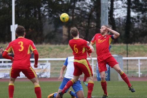 Needhams Kieran Morphew (R) heads clear from Simon Thomas supported by Dan Morphew (6) and Callum Sturgess