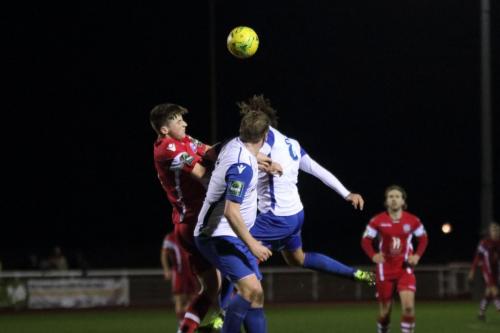 Tonbridges Liam Smith heads clear from Sam Youngs (R) and Mark Kirby