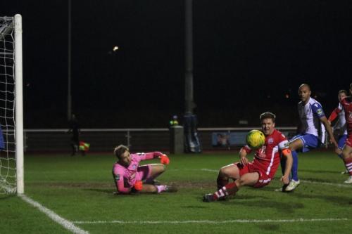 Tonbridges Sonny Miles (red) tidies up after keeper Jonathan Henlys block from a free kick