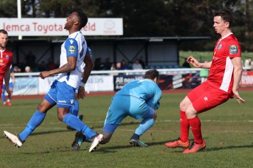 Billericay keeper Alan Julian beats Ryan Blake (L) to the ball as Kevin Foley covers