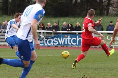 Billericays Jamie OHara (red) blocks a shot from Aaron Greene
