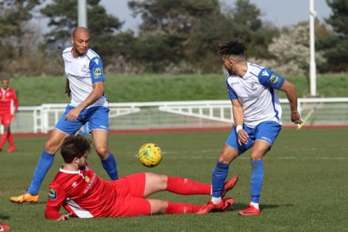 Billericays Josh Urquhart slides the ball away from Tyler Campbell (R) and Simon Thomas