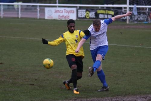 Enfields Mark Kirby (R) clears from Andre McCollin