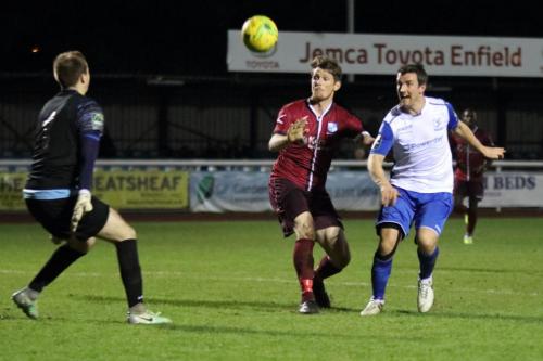 Enfields Elliot Benyon (R) chips the ball over Wingate keeper Luke Sheldrick but just wide of the goal
