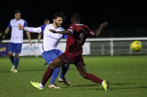 Enfields Mario Noto (L) plays the ball past the challenge of Nathan Mavila