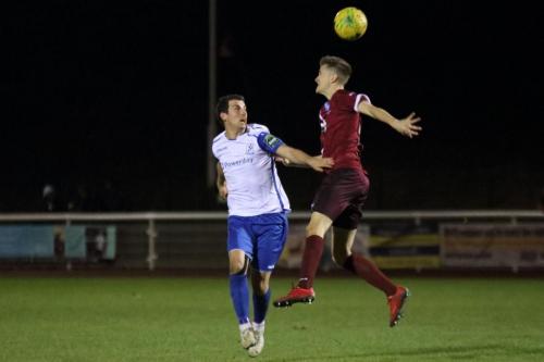 Wingates Jake Eales (R) heads clear from Elliot Benyon