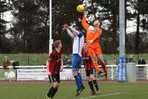 Brightlingsea keeper James Bradbrook punches clear from Brad Wadkins
