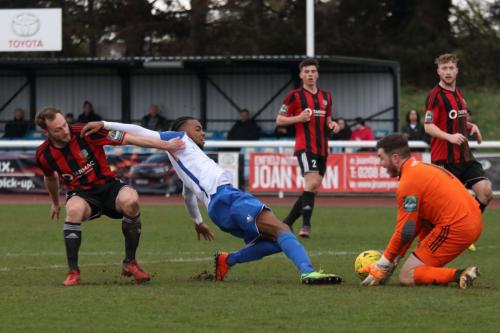 Brightlingsea keeper James Bradbrook saves from Dernell Wynter as Jake Gould covers45