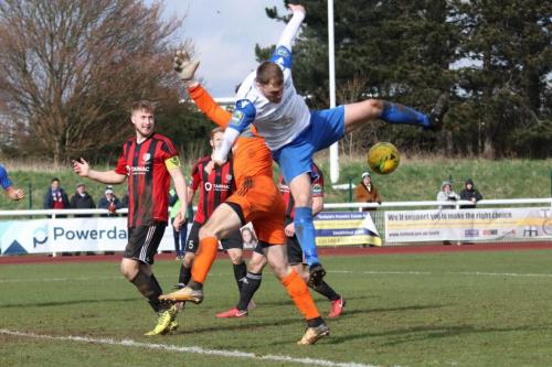 Enfields Brad  Wadkins is adjudged to have fouled Brightlingsea keeper James Bradbrook