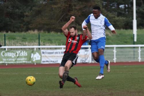 Jake Gould (L) gets back to tackle Ryan Blake after Blake had collected a poor kick from Brightlingsea keeper James Bradbrook