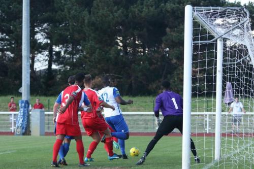 A Harrow defender clears the ball just ahead of Enfields Rob Bartley (12)