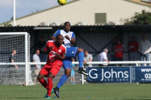 Enfields Rob Bartley clears from Richard Pacquette (red)