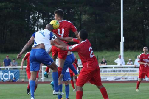 Enfields Simon Thomas beats his marker Shaun Preddie (2) to head the winner