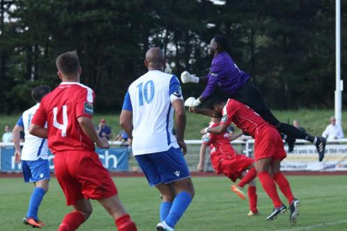 Harrow keeper Melvin Minter punches clear, taking out teammate Howard Hall in the process