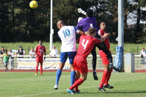 Harrow keeper Melvin Minter punches clear from Simon Thomas