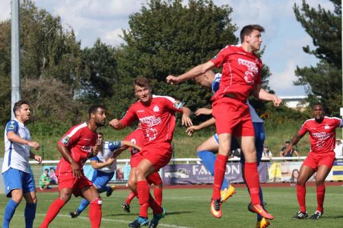 Harrows Will Turl (red )heads clear from a corner