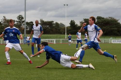 Margates Tom Mills (centre) sends a diving header back to his goalkeeper