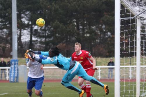 Enfields Liam Hope gets his head to the ball just ahead of Merstham keeper Ashlee Jones