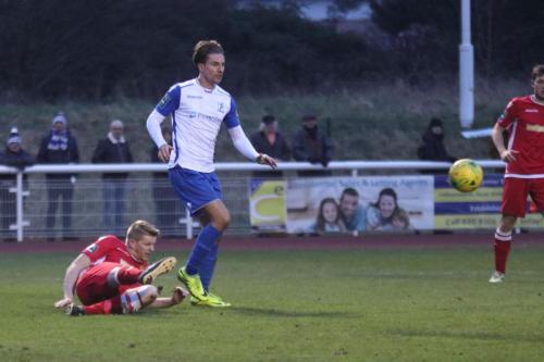 Mersthams Liam Harwood (red) clears from Sam Youngs