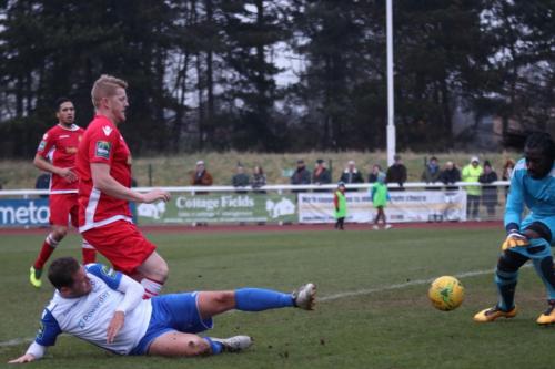 Mersthams Liam Harwood (red) does just enough to stop Liam hope getting a clean strike