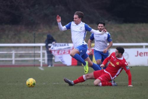 Mersthams Tom Kavanagh (red) challenges Sam Youngs