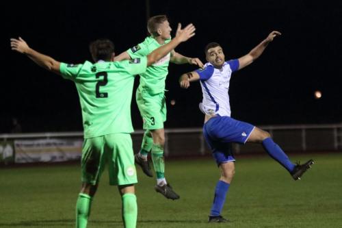 Dorkings Chris Boulter (centre) heads clear from Taylor McKenzie