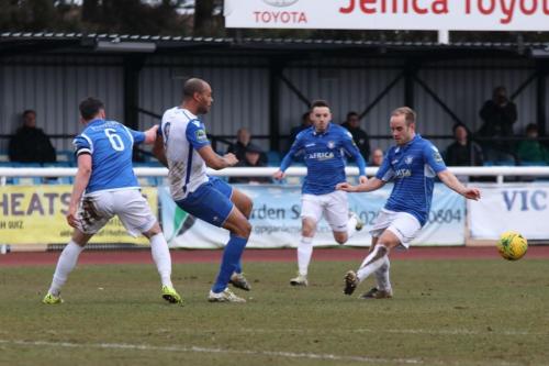 Enfields Simon Thomas (white) lays the ball off under the challenge of Travis Cole (6) and Andrew Fisk