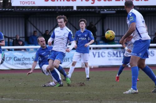 Lowestofts Andrew Fisk (blue) clears from Mickey Parcell