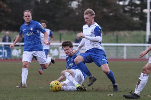 Lowestofts Harvey Hodd (blue, R) challenges Ryan Blackman