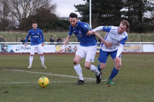 Lowestofts Rory McAuley (blue) and Enfields Aaron Greene