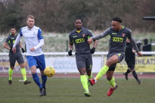 Staines Joash Nembhard (R) clears watched by Brad Wadkins (L) and Ugo Udoji