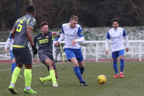 Staines Josh Webb (grey, R) challenges Brad Wadkins