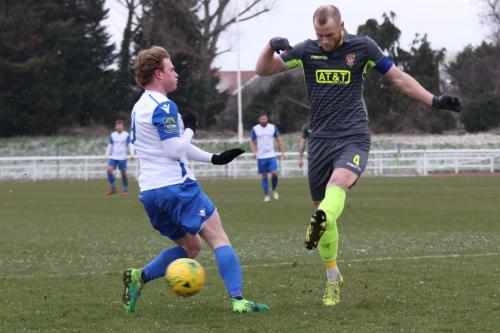 Staines Sam Hatton clears from Aaron Greene