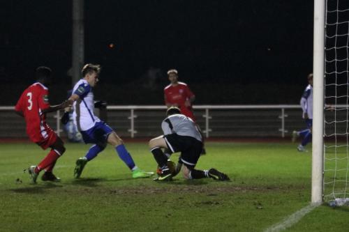 Chipstead keeper Michael Sibley saves at the feet of Ben Ward-Cochrane