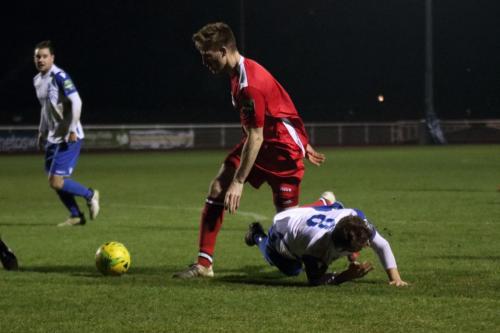 Chipsteads Sam Bell (red) brings down Jack Hockney to concede a penalty
