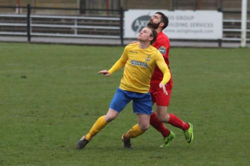 Enfields Aaron Greene (L) and Harrows Ryan Moss keep their eyes on the ball