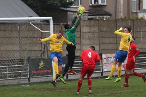 Harrow keeper Melvin Minter catches under pressure from Brad Wadkins (L)