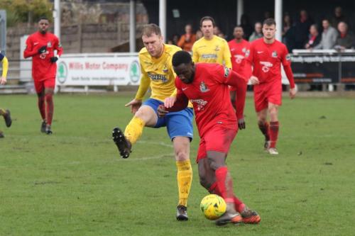 Harrows Adam Pepera (red) clears from Brad Wadkins