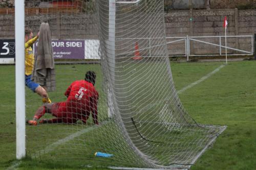 Harrows Adam Pepera (red) makes sure Brad Wadkins cant force the ball in at the far post
